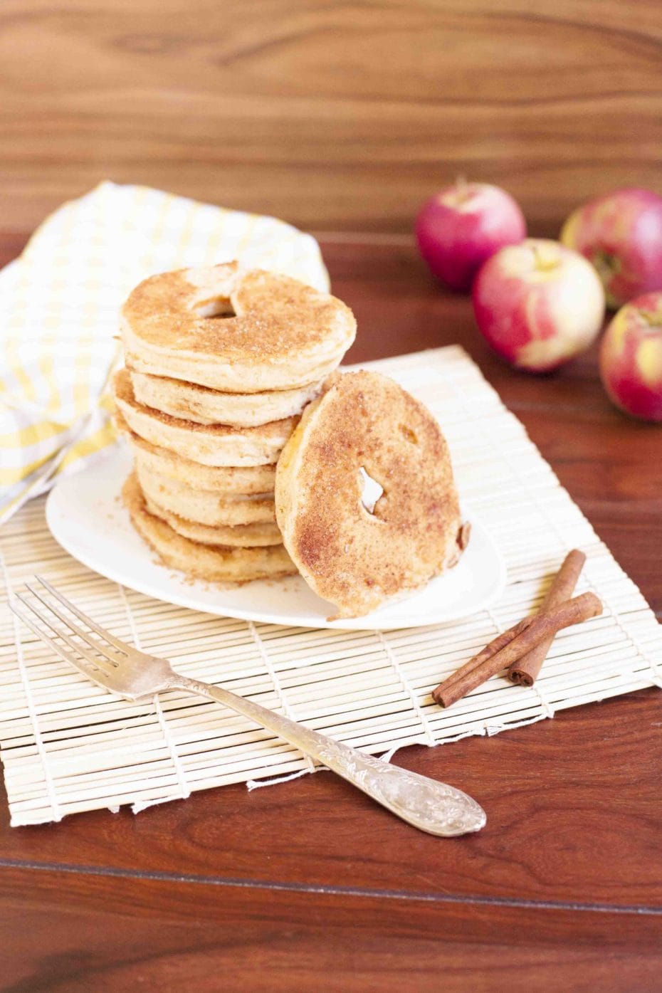 Stack of cinnamon fried battered apple rings on a white plate. 