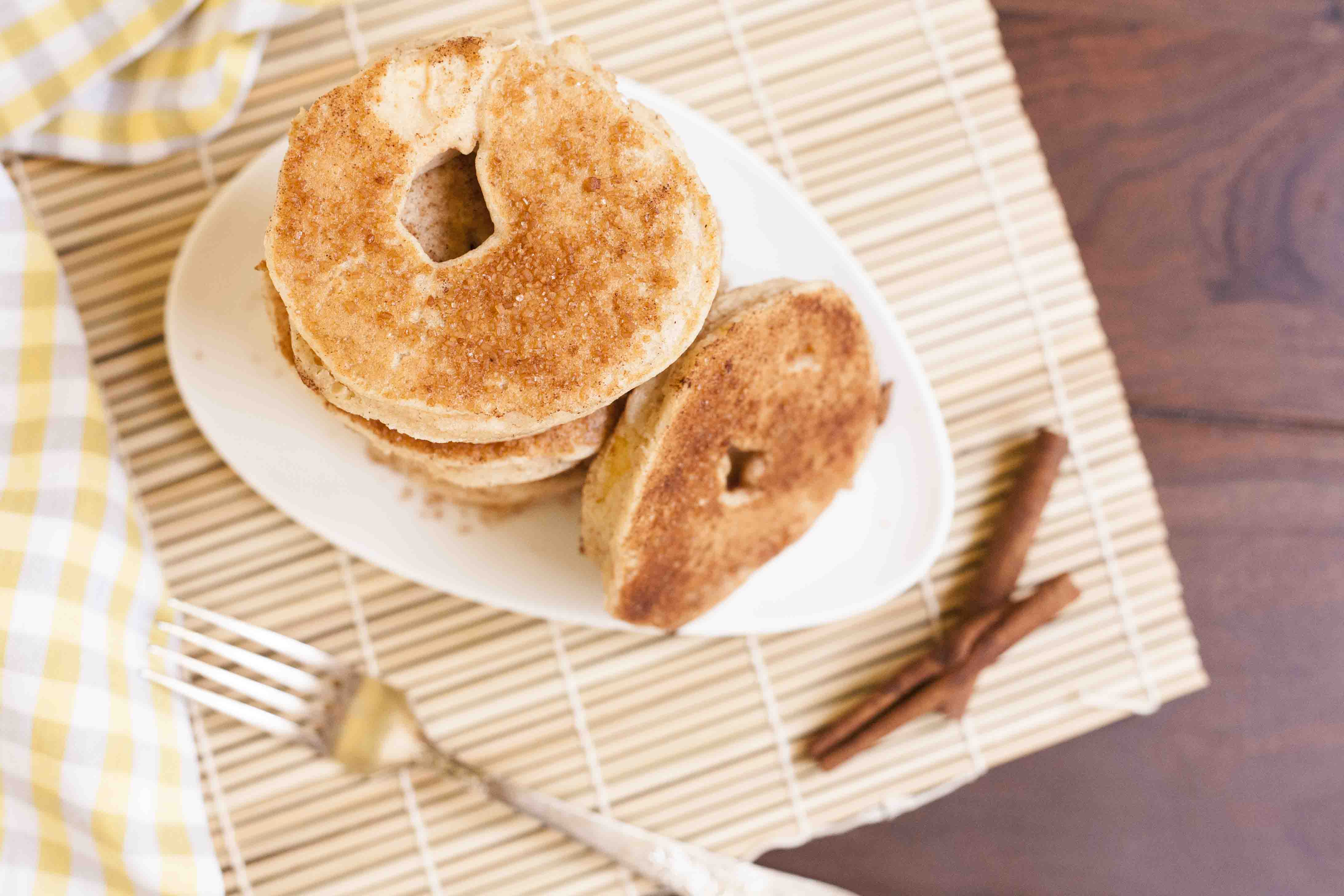 Stack of cinnamon fried battered apple rings on a white plate. 