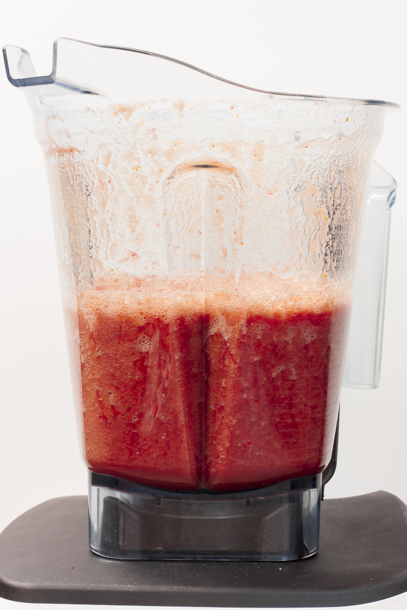 Blender from the side containing red liquid.