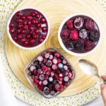 3 small bowls, one with vegan chocolate pudding topped with mixed berries, the other topped with red currant and one bowl is only fruits.