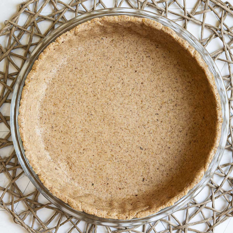 Glass pie pan with brown unbaked pie crust