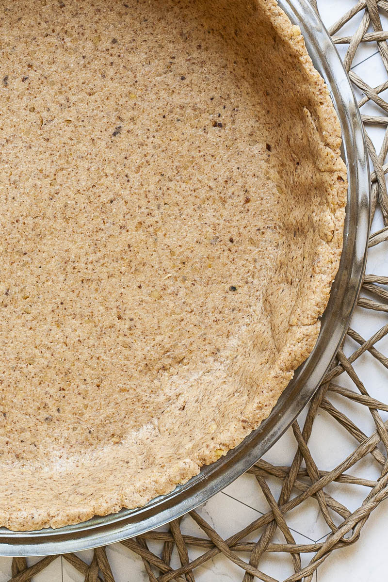 Glass pie pan with brown unbaked pie crust