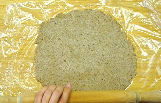 Rolling out the gingerbread pie dough on a wooden board - from above