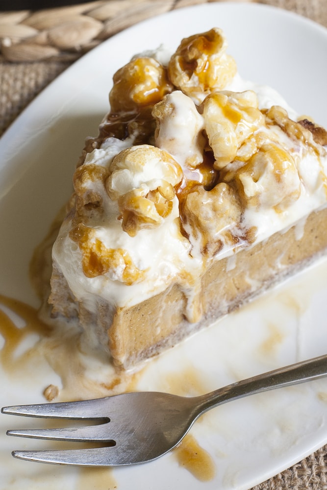 A slice of pumpkin cheesecake with gingerbread crust to show how does the pie crust looks in action