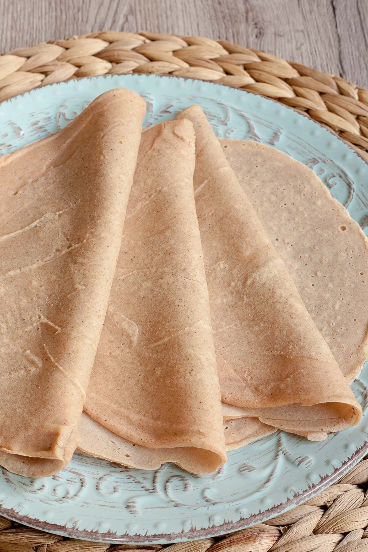 3 tortillas folded in half on top of one flat placed on a light blue plate
