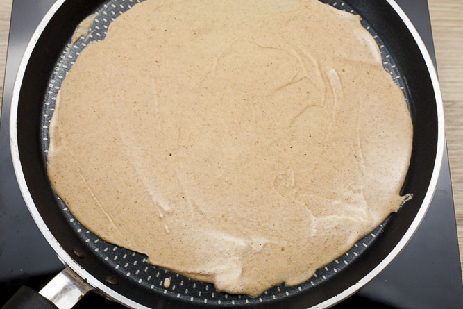 Black frying pan from above with a light brown redish thick tortilla.