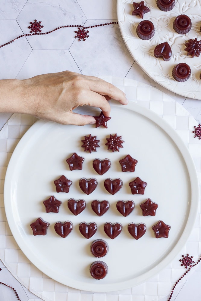Several types of cranberry jelly shaped as hearts or stars scattered around to form a Christmas tree from above
