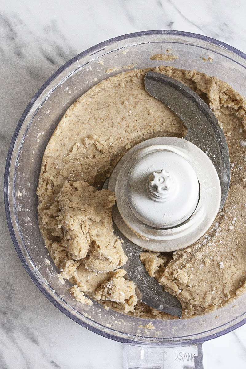 Open food processor from above showing how the pie dough looks like after mixing. 
