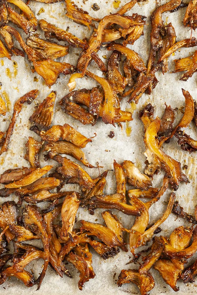 Crispy baked shredded oyster mushrooms in a white parchment paper turned into vegan gyro meat