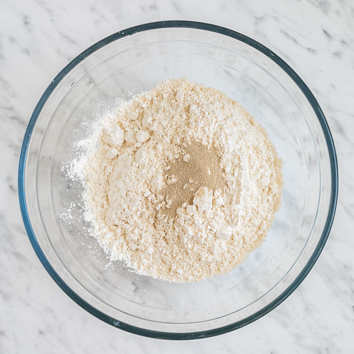 Glass bowl with flour and dry yeast.