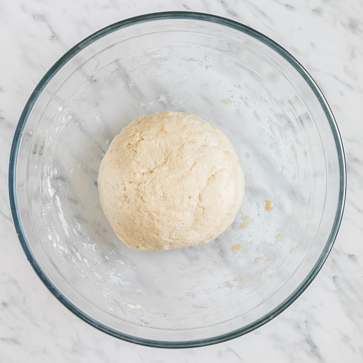 Glass bowl with a ball of white dough
