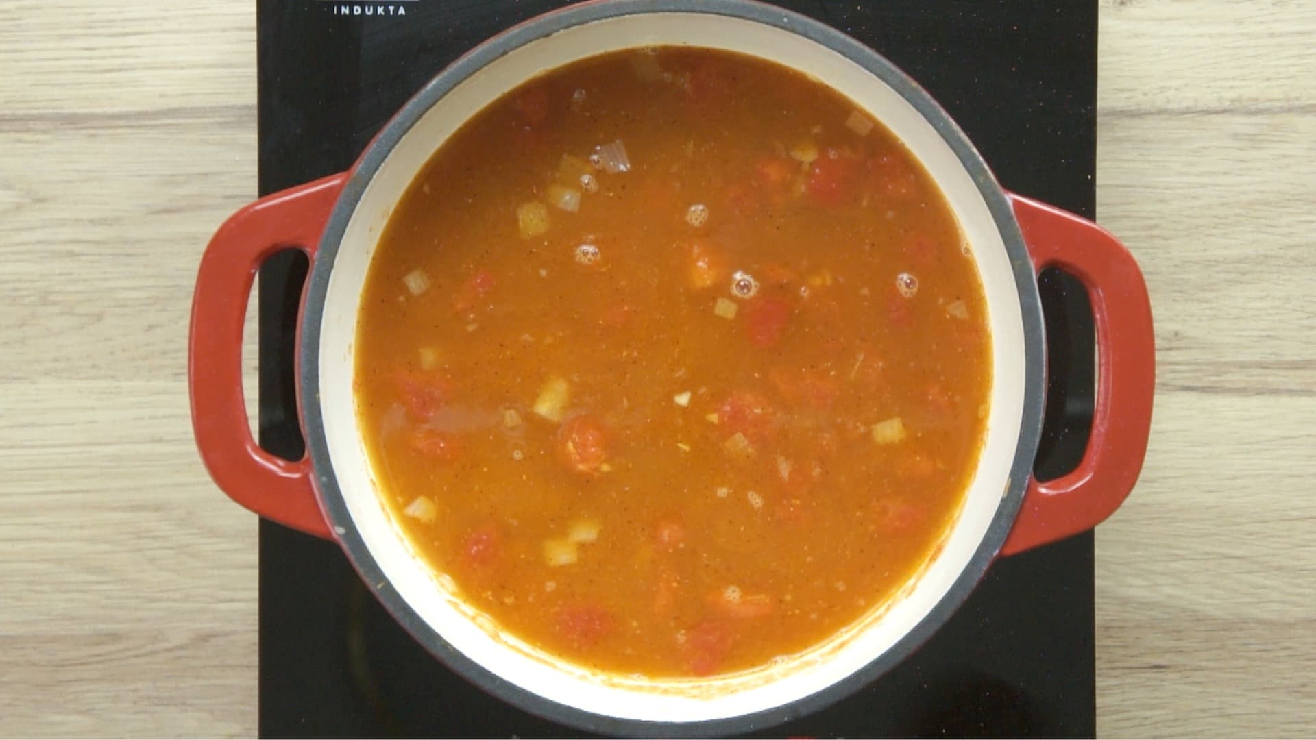 Red chunky soup in a red enameled Dutch oven