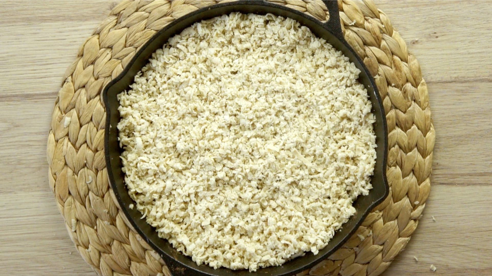 Black cast-iron skillet with grated crumbles.