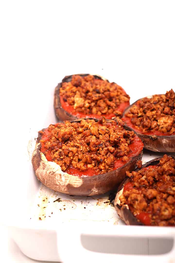 3 Large mushroom caps with red sauce and dark brown sausage crumble