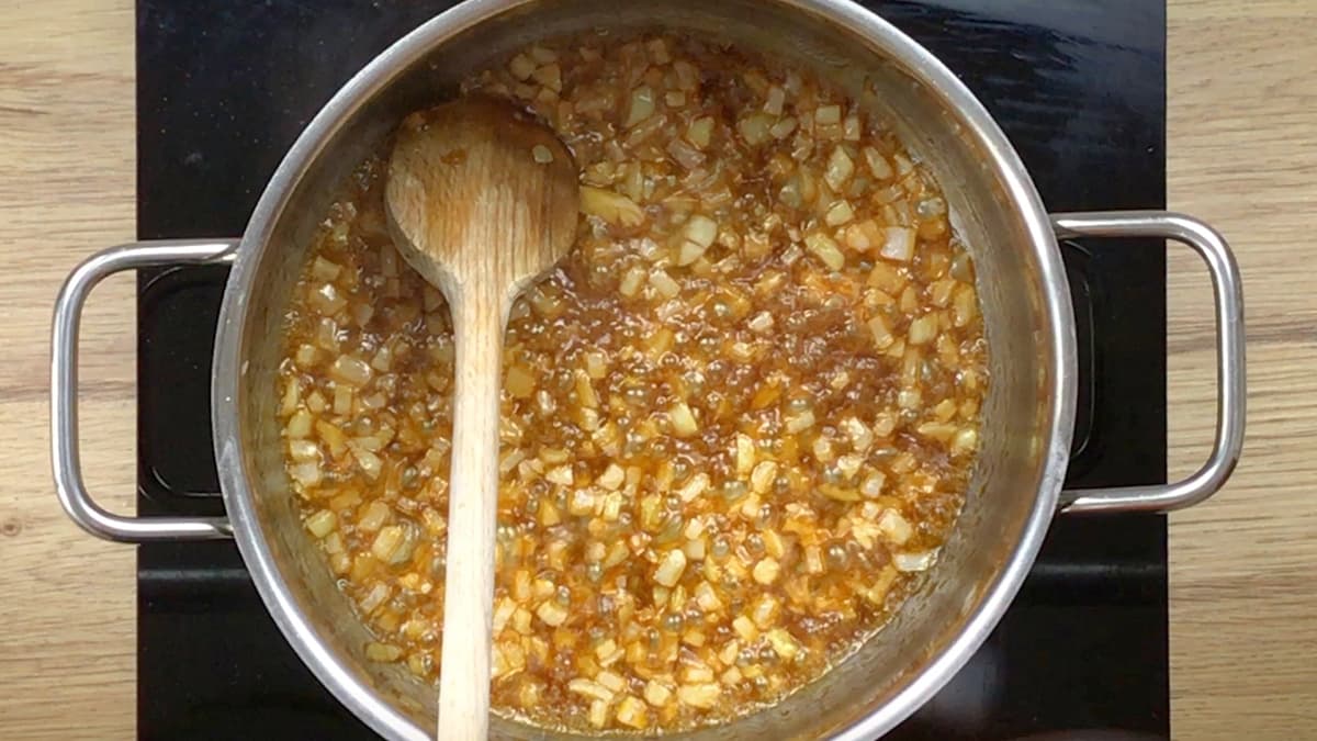 Large pot with brown caramel and onion pieces.
