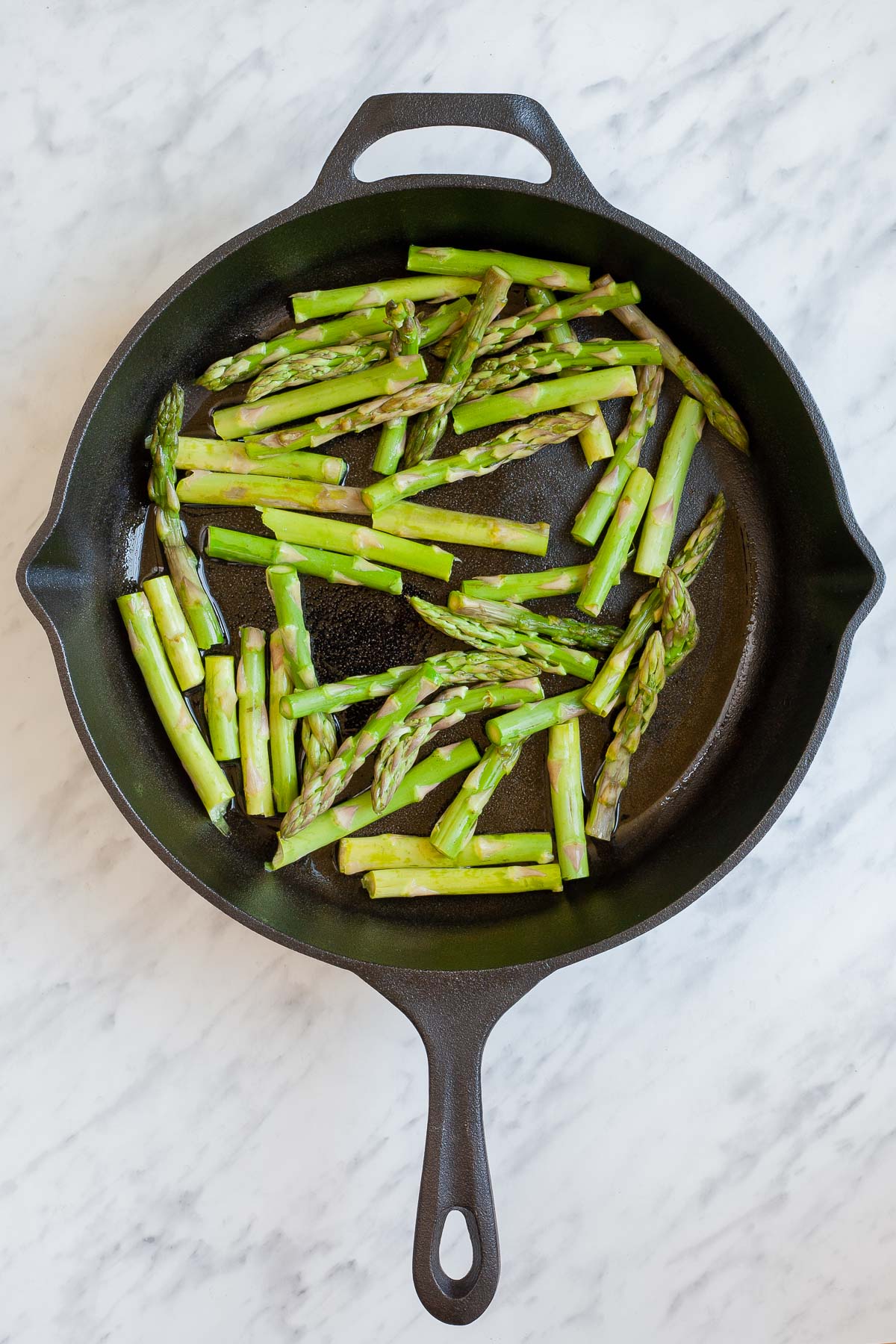 Cast iron skillet with asparagus pieces. 