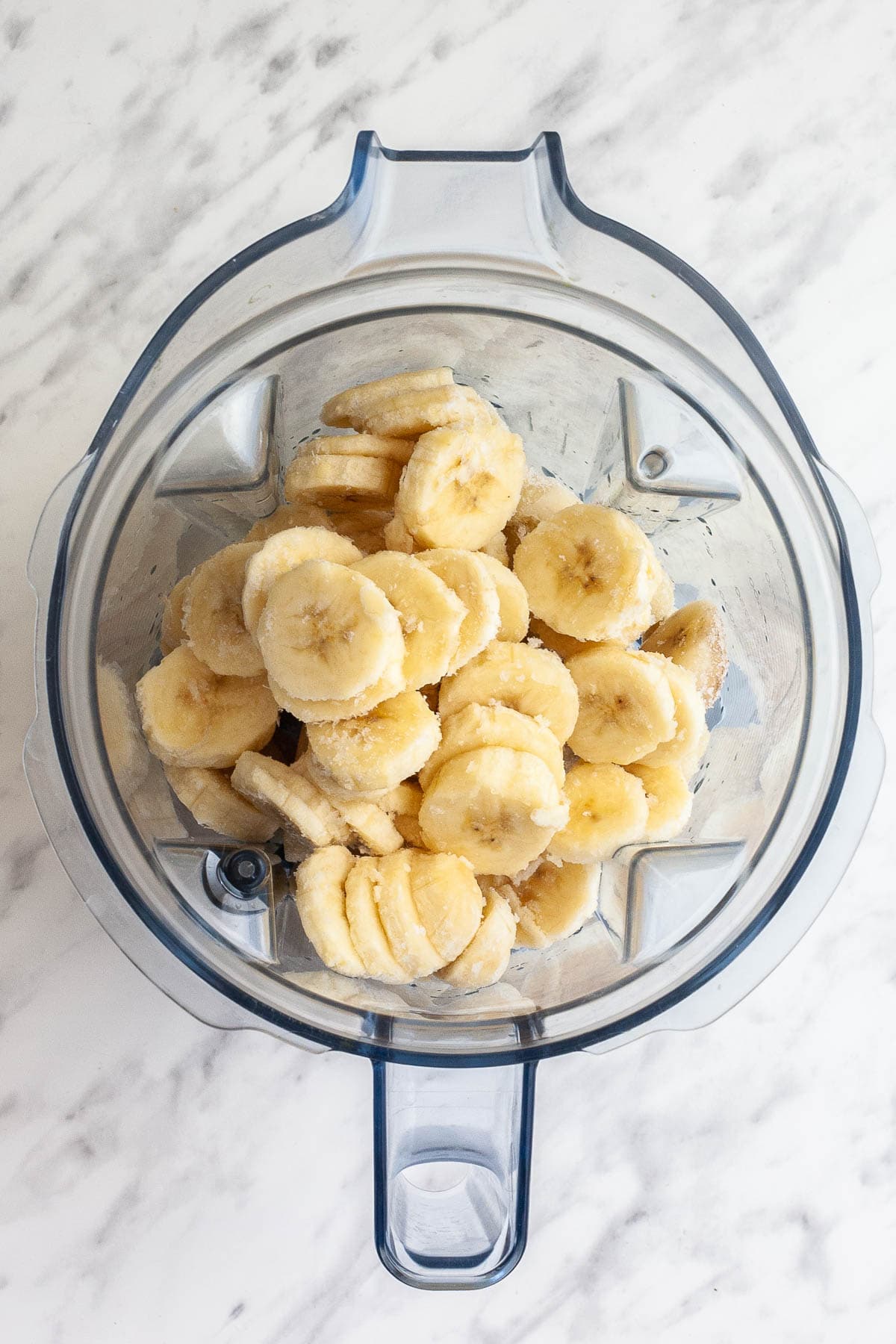 A blender from above with frozen banana slices