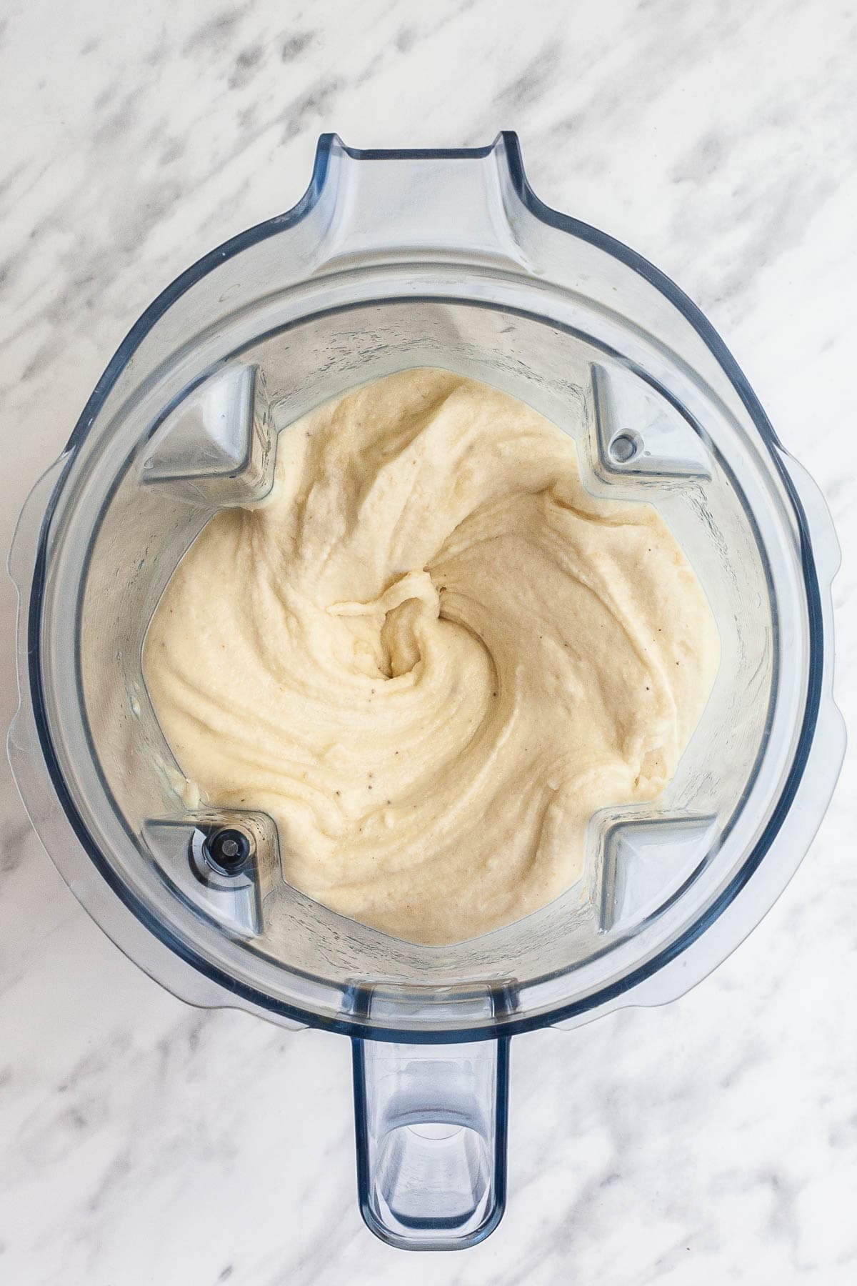 A blender from above with light brownish ice cream