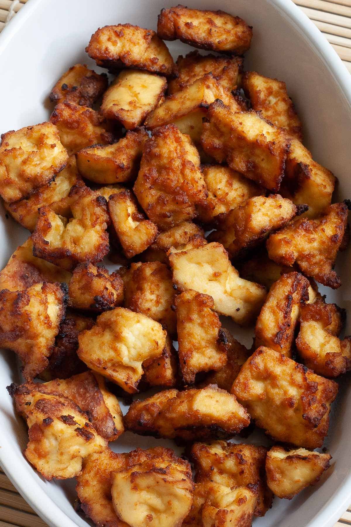 White bowl with yellow-brown tofu bites