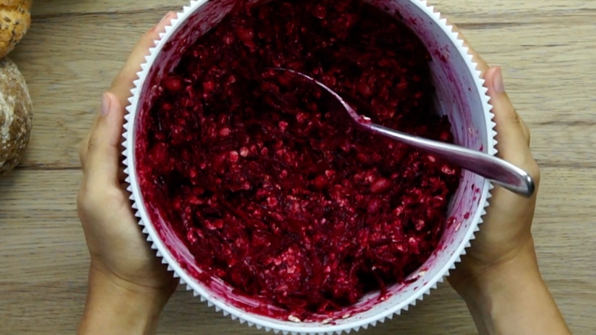 White mixing bowl with purple chunky mixture for burger patties.