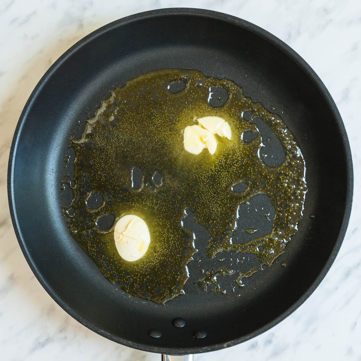 Black frying pan with melted butter. 
