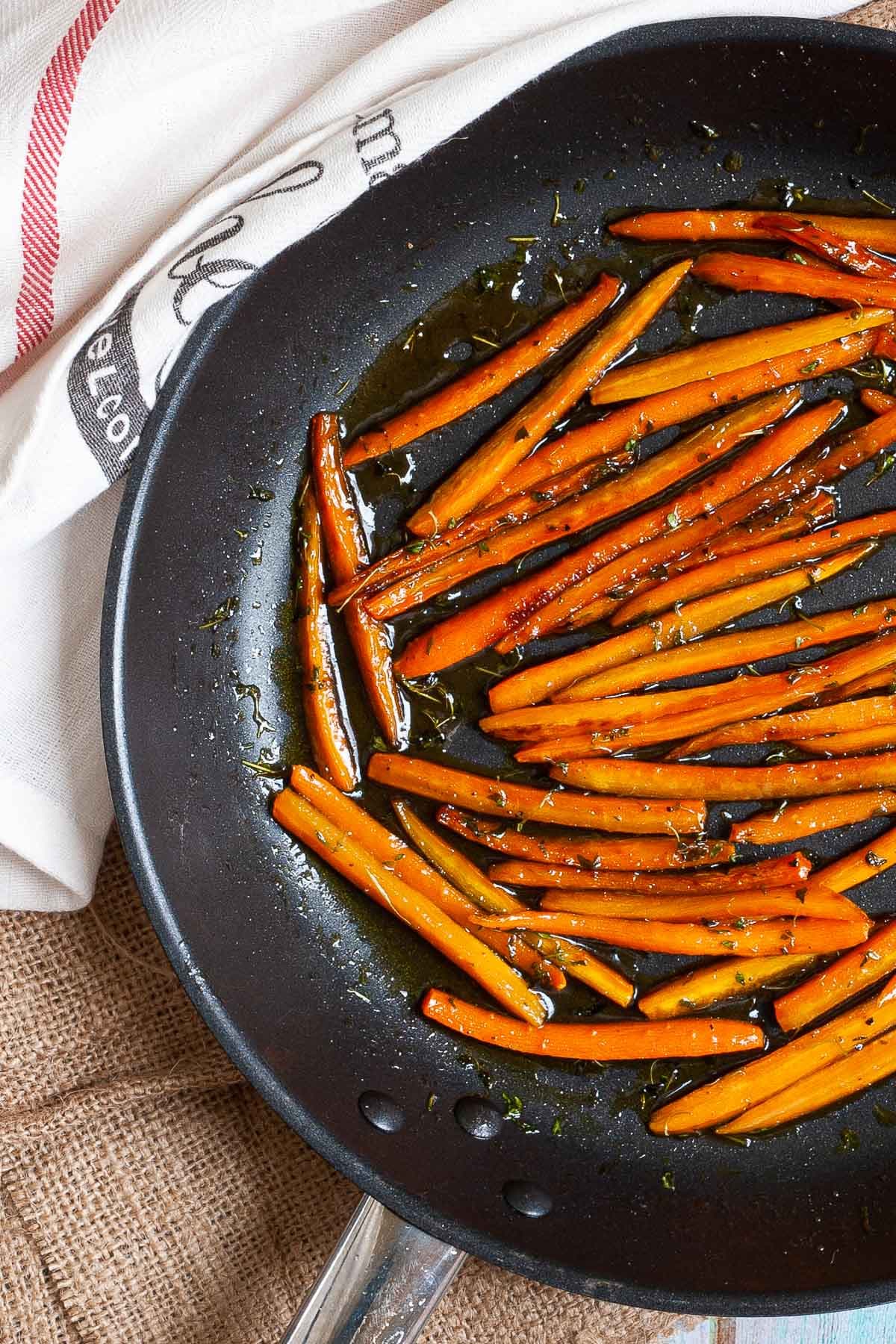Frying pan with matchstick carrots in a glaze.