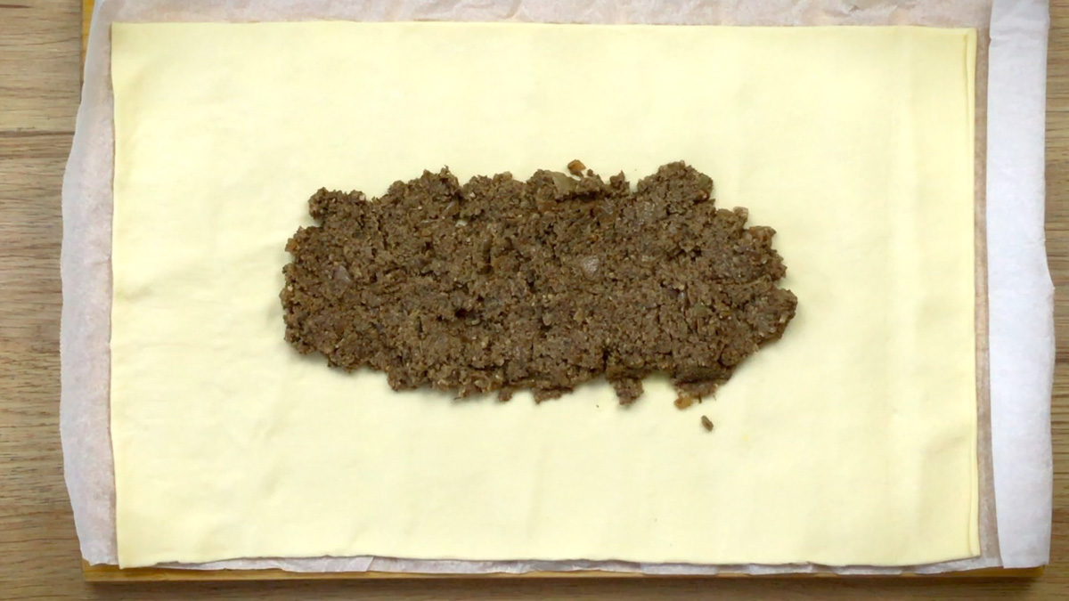 Yellow puff pasty with  a large heap of thick green paste in the middle. 