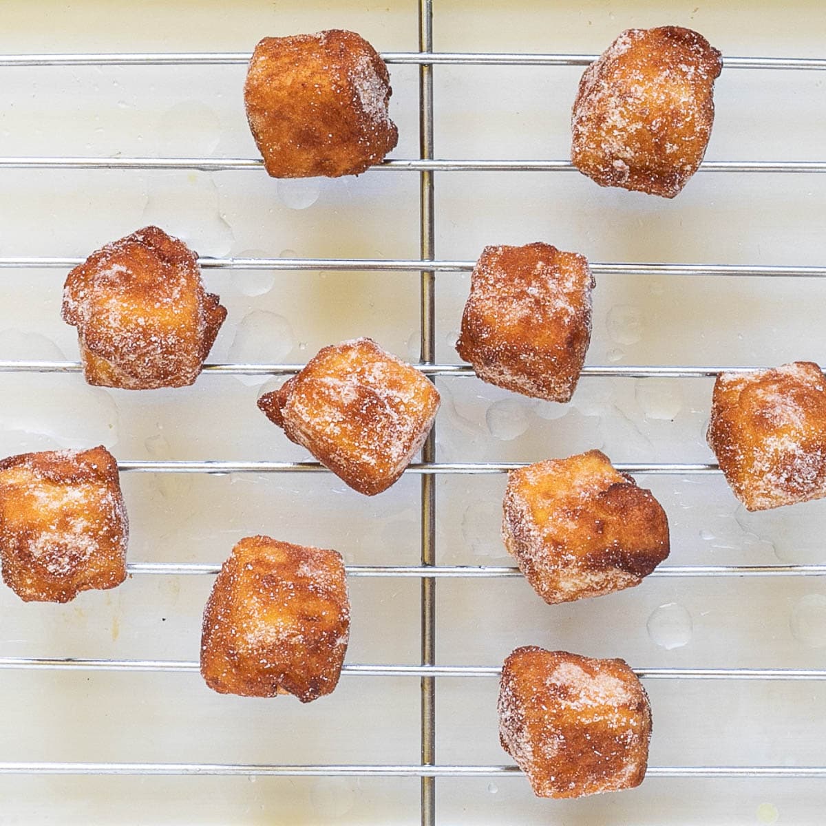 Crispy breaded deep-fried tofu cubes are placed on a grill rack.