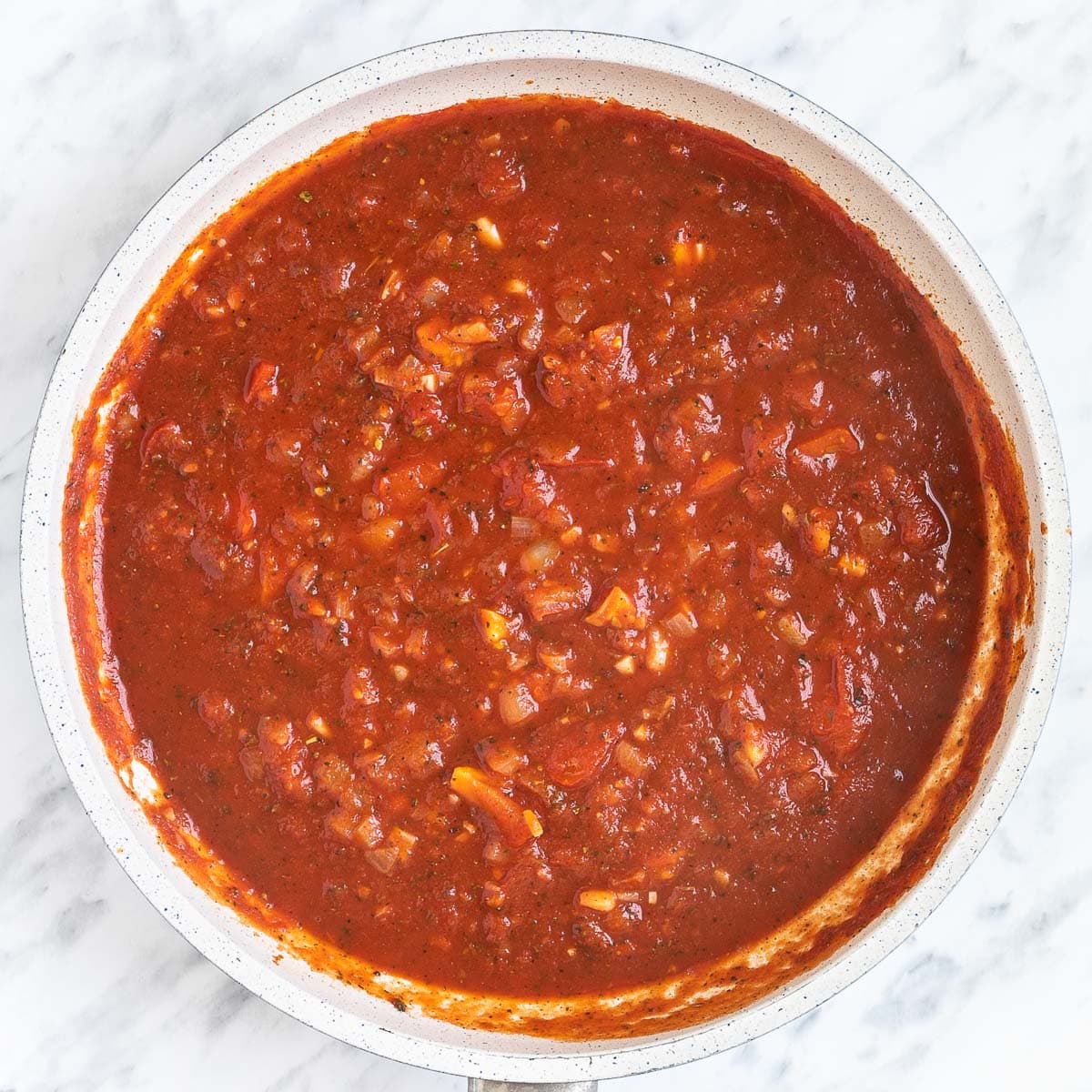 Chunky tomato sauce in a white frying pan