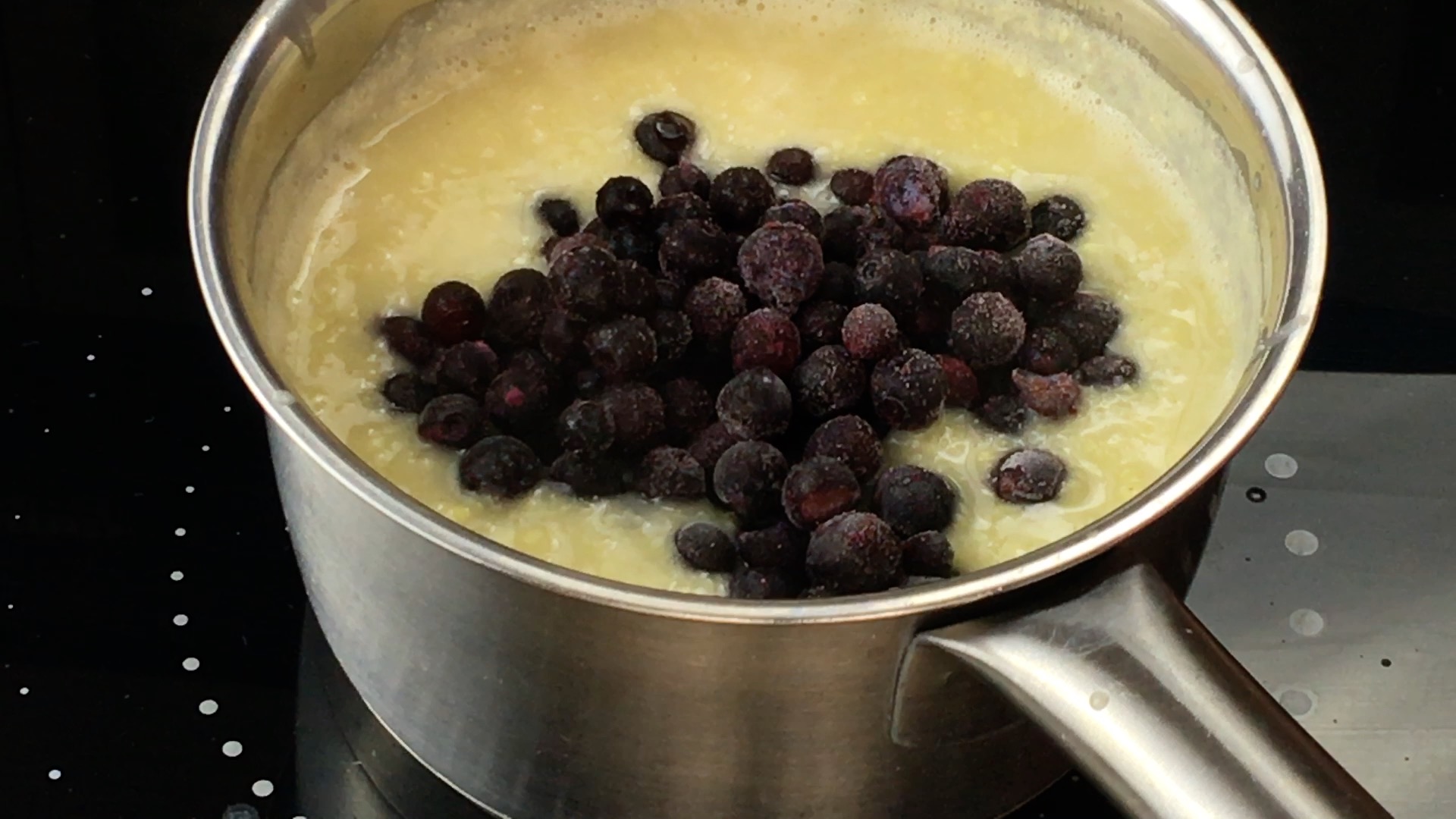 Yellow porridge with frozen blueberries