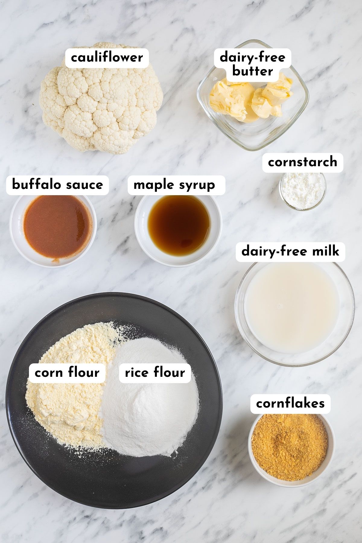 Ingredients of buffalo cauliflower in small bowls and a cauliflower head