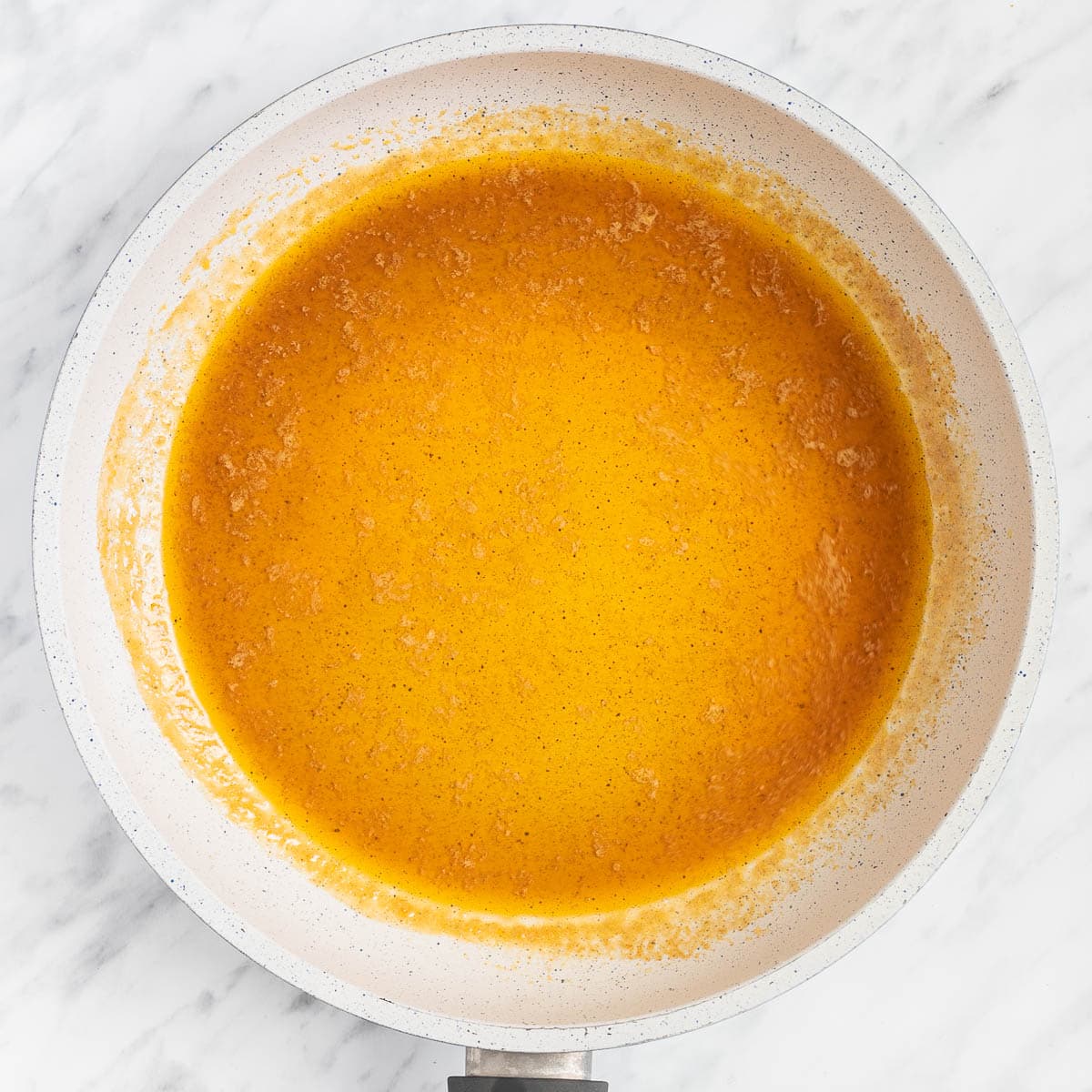 Light orange sauce in a white frying pan