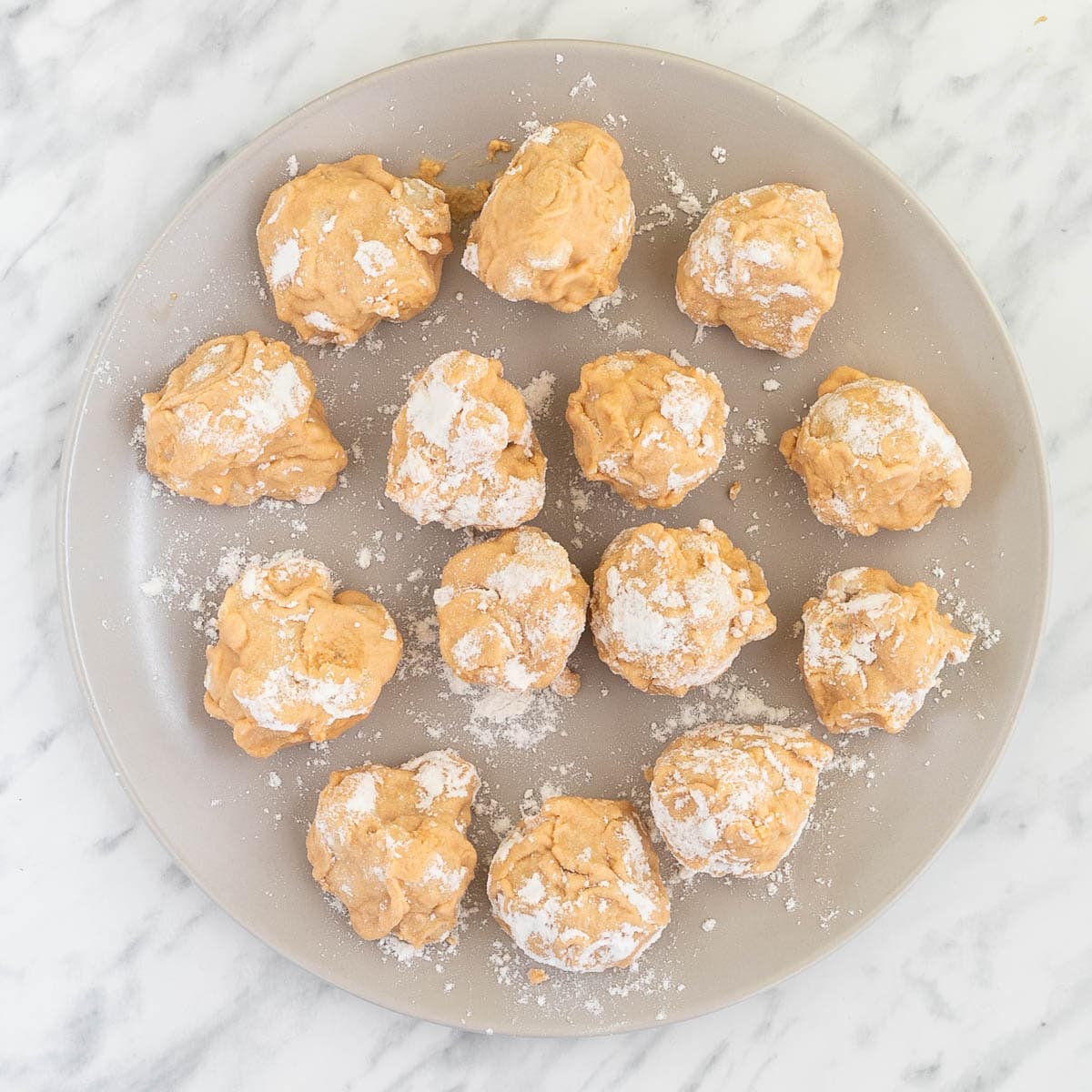 Orange colored battered cauliflower florets on a gray plate.