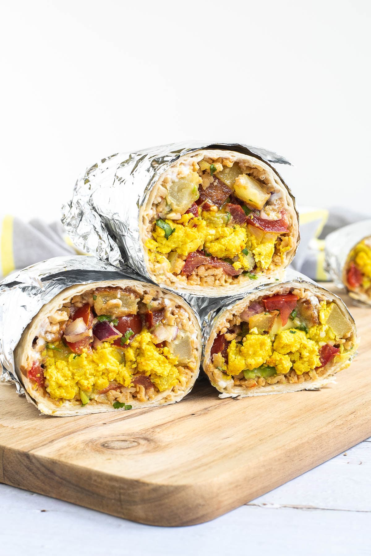 3 half tortillas wrapped in tin foil filled with sausage crumbles, diced potatoes, tofu scrambles, and avocado tomato salsa. 