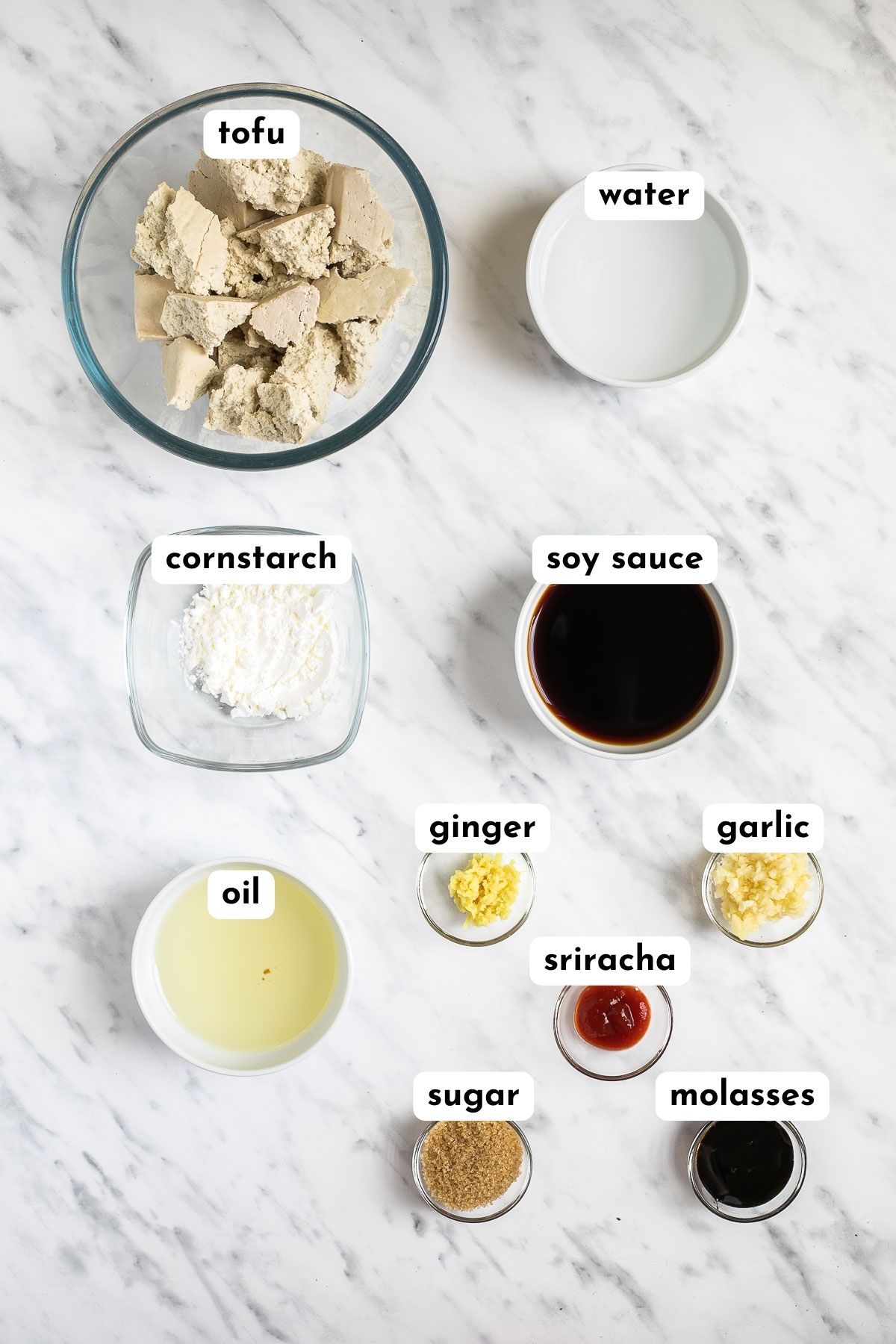Ingredients of hoisin tofu in small bowls like tofu, sugar, starch, soy sauce, oil, minced garlic, ginger, water, molasses, and sriracha