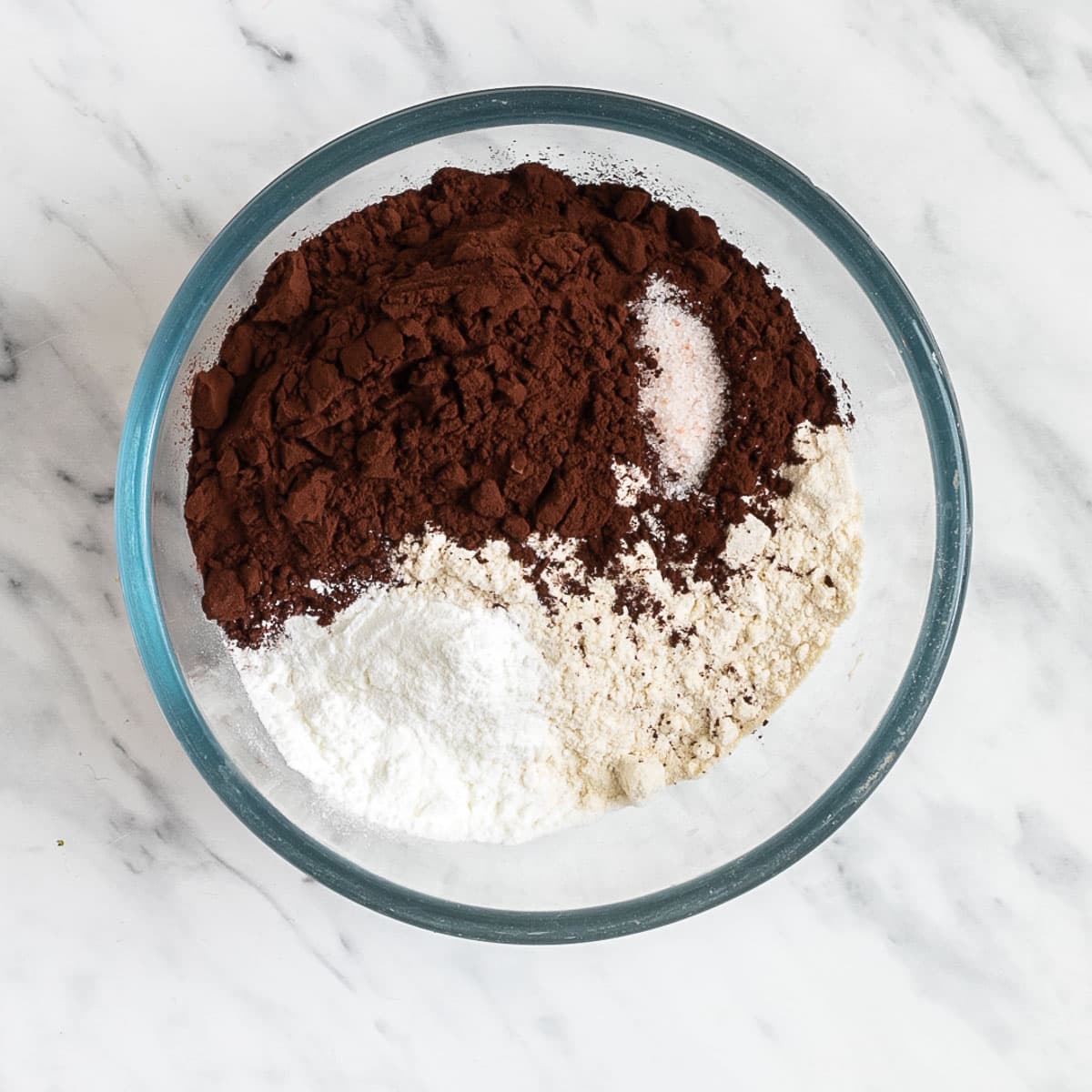 Glass bowl with cocoa powder, flour, salt, and baking powder.