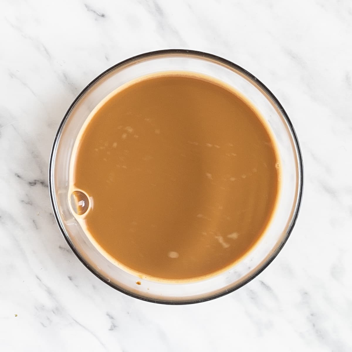 A coffee colored liquid in a small glass bowl.
