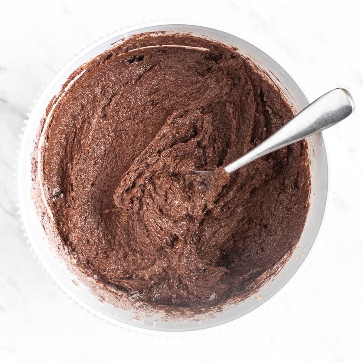 Soft dark brown batter in a white bowl.