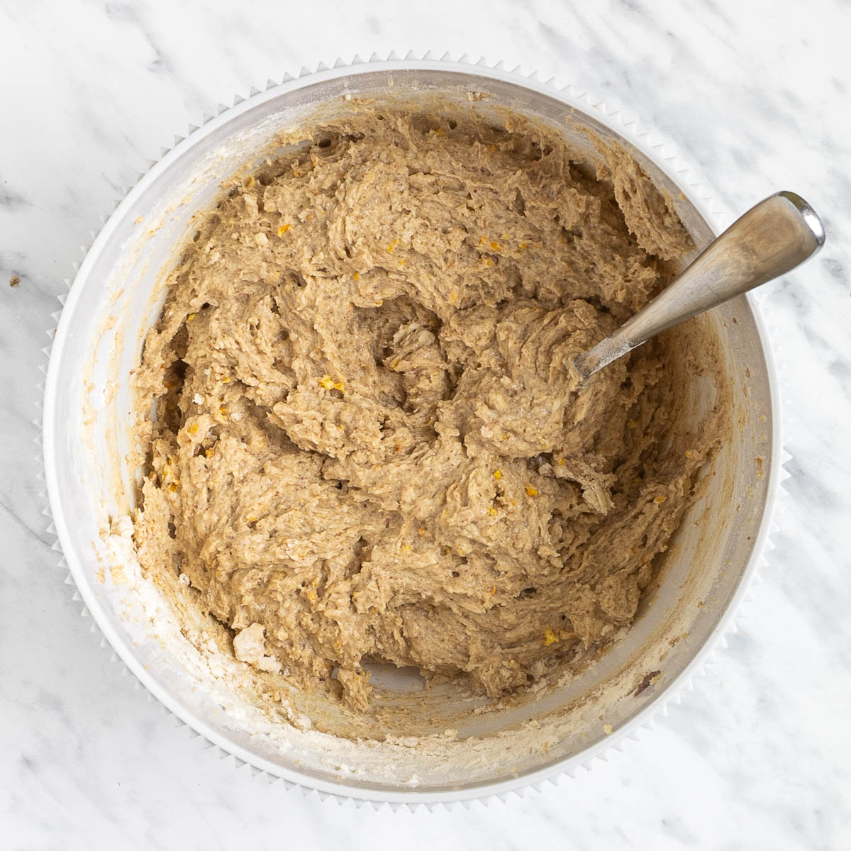 Soft light brown batter in a white bowl.