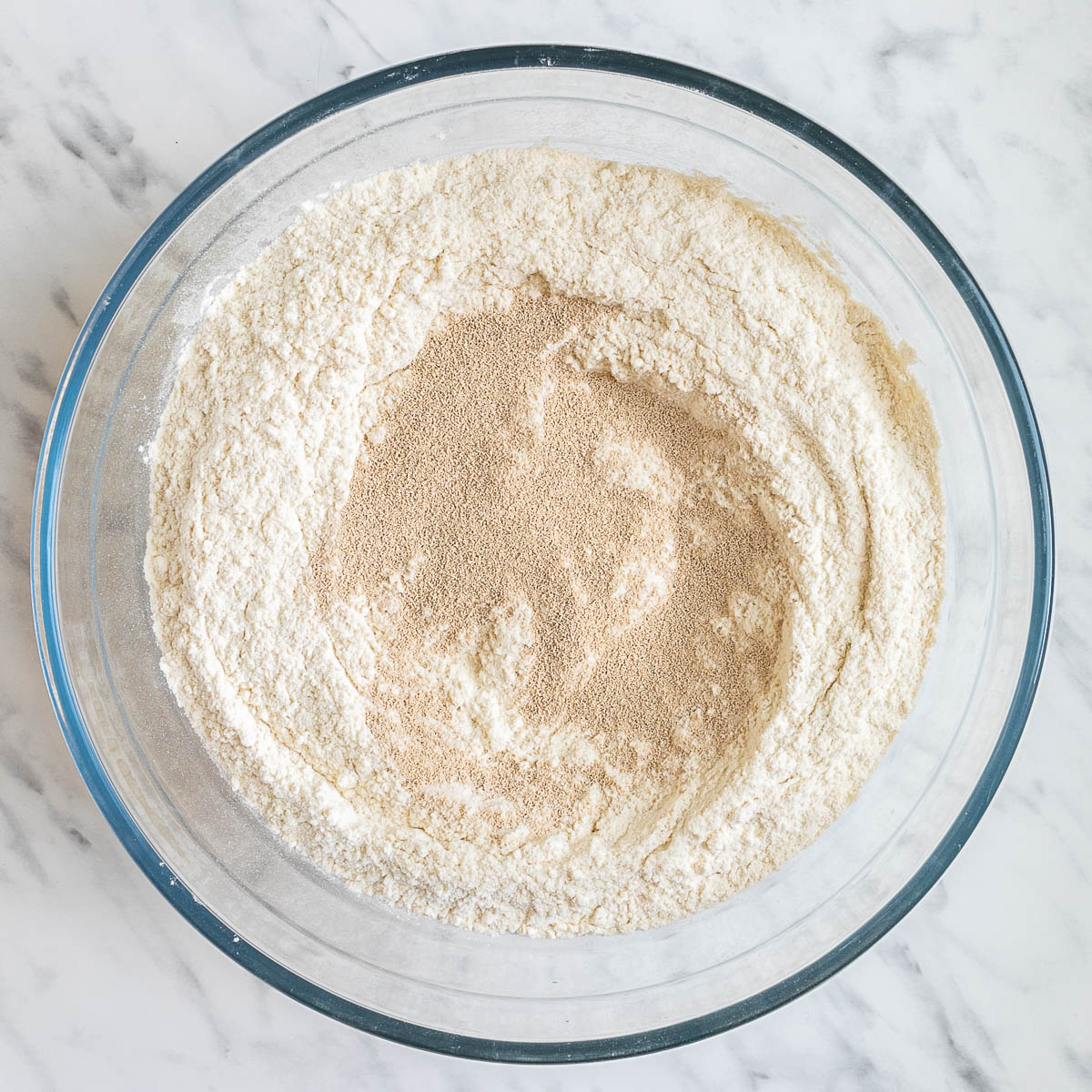 Glass bowl with flour and dry yeast.