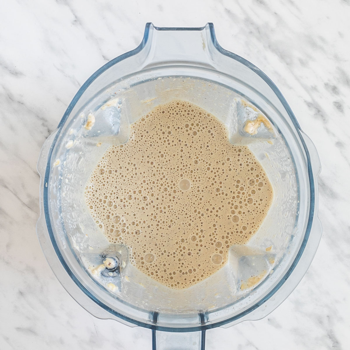 A blender from above with a white sauce