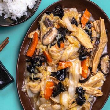 Large brown bowl of cabbage, wood ear mushroom, tofu skin in a brown stew