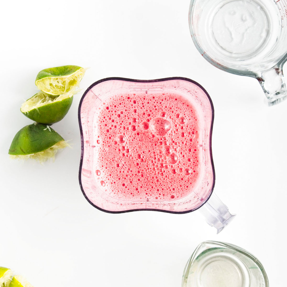 A blender with pink foamy liquid.