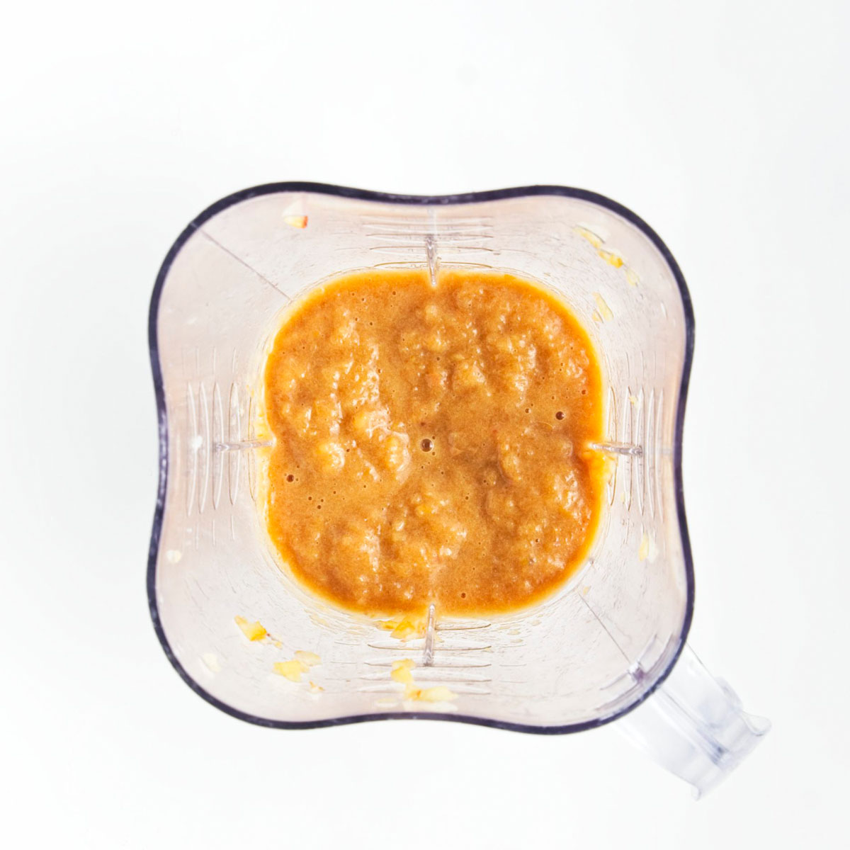 A blender with orange colored puree.