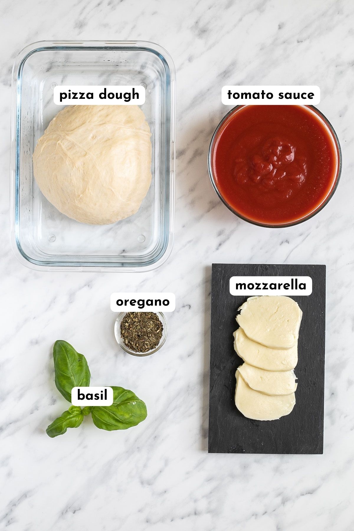 Ingredients of vegan pizza in small containers like pizza dough, tomato sauce, basil, oregano, and mozzarella.