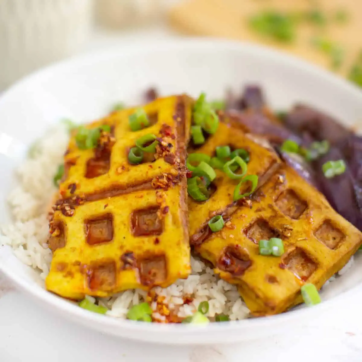 Small waffles of brown and yellow served on top of white rice.