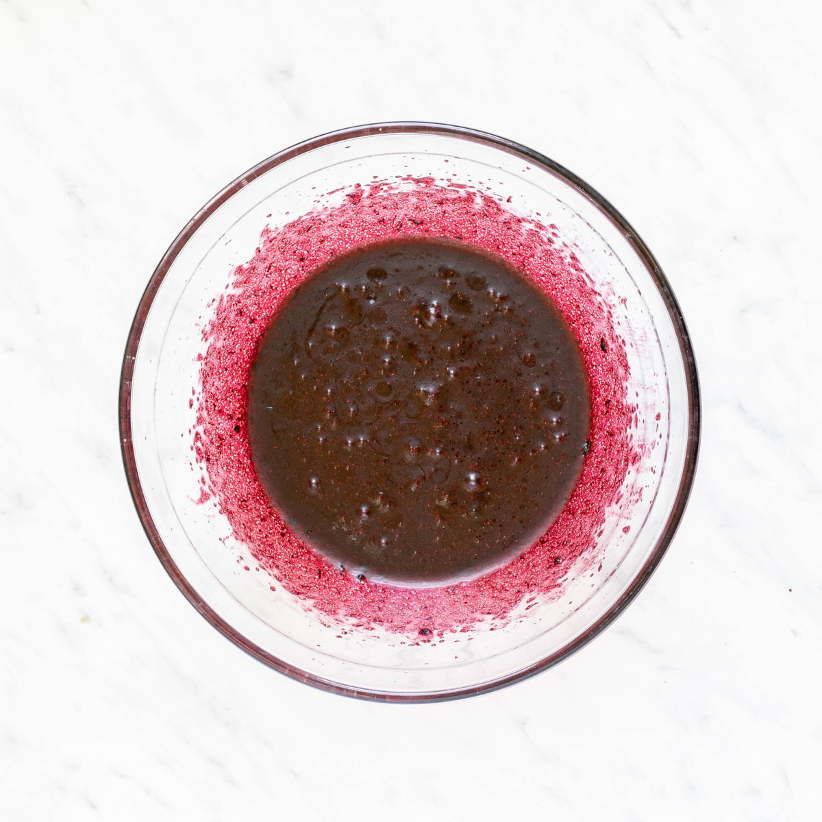 A glass bowl with dark purple liquid. 