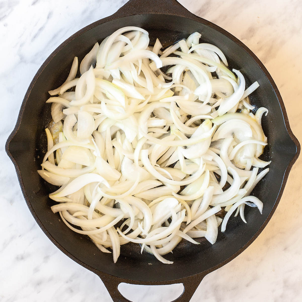 Black cast iron skillet with sliced onion.