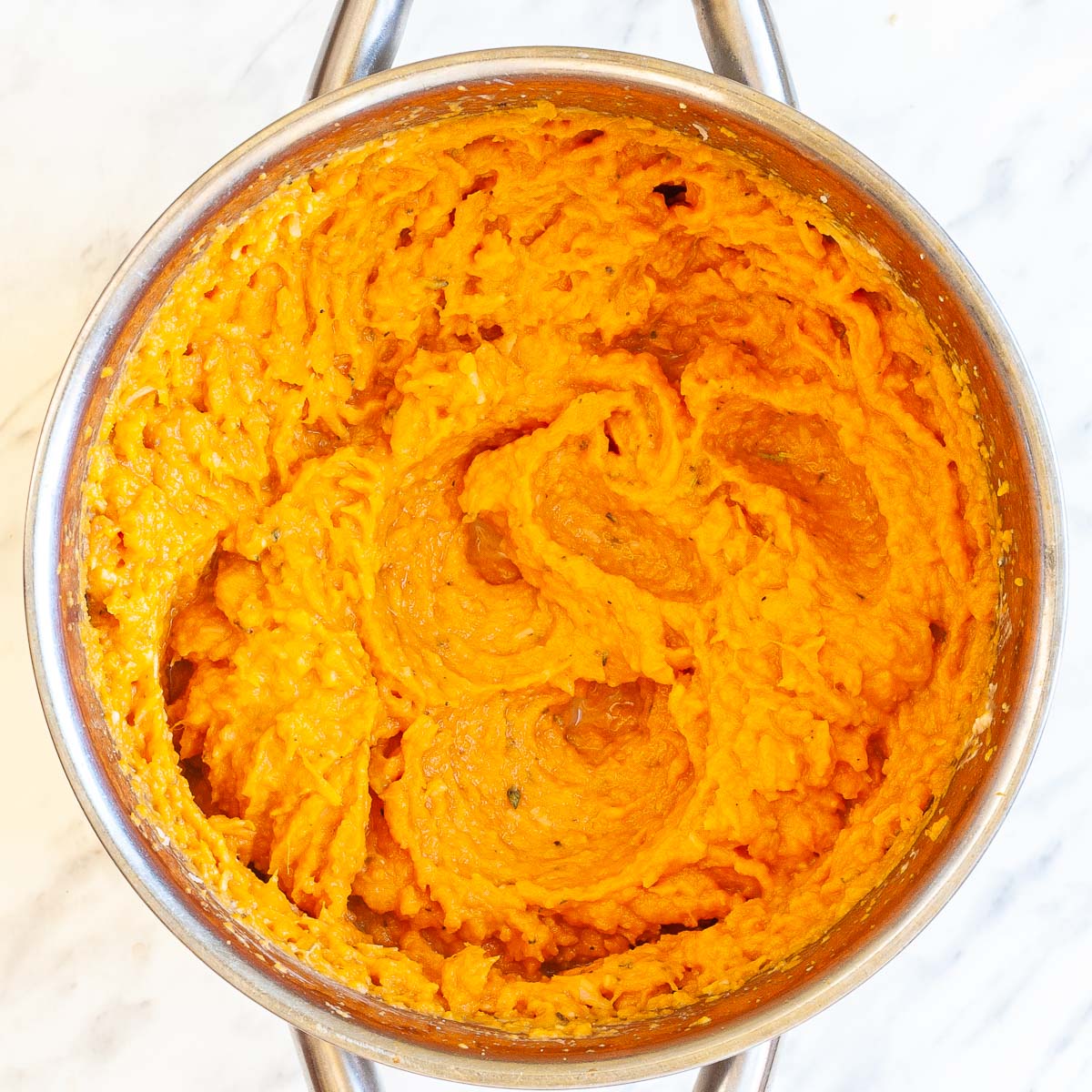 Stockpot with creamy mashed orange sweet potatoes.