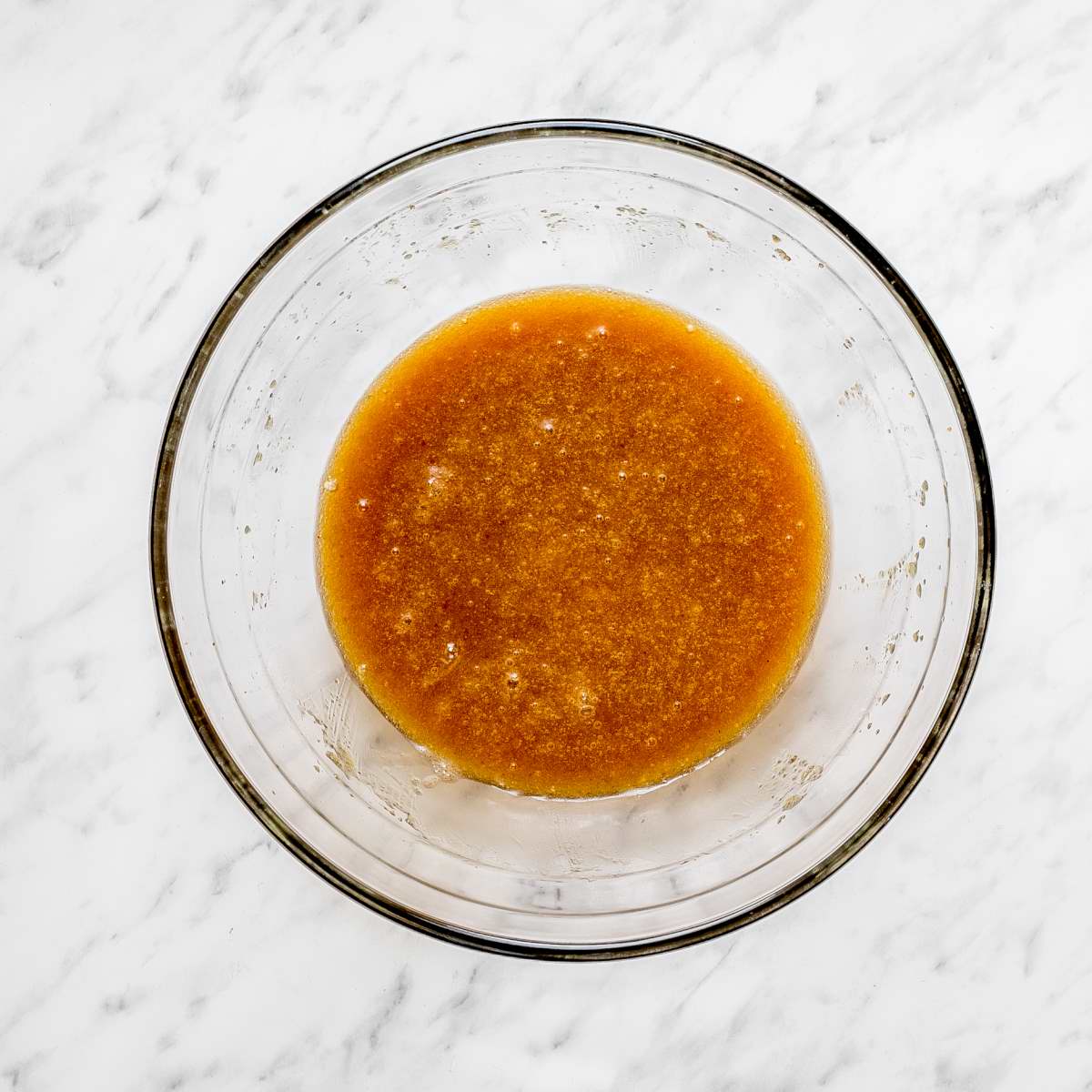 Glass bowl with caramel color liquid.